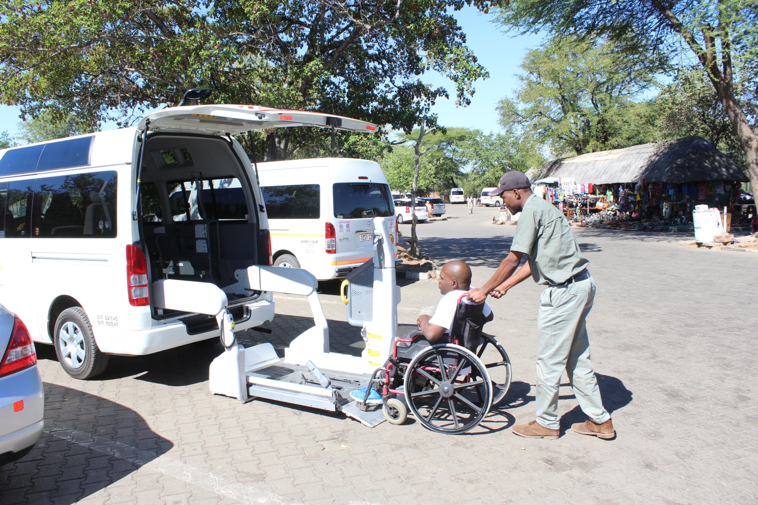 Guide assisting a traveller using an accessible safari vehicle